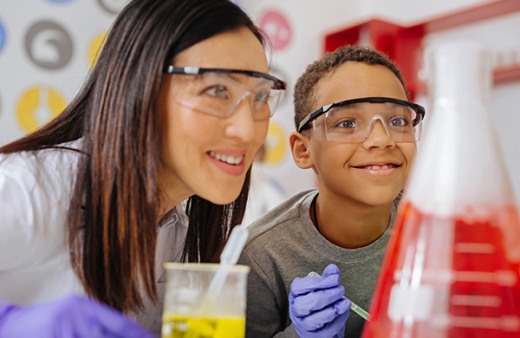 Teacher and elementary student conducting a science experiment