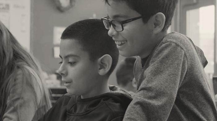 two young boys looking at a computer