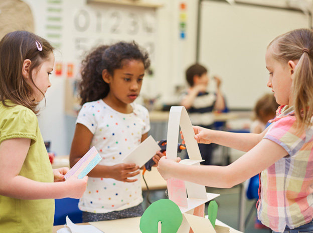 Elementary students building a paper structure