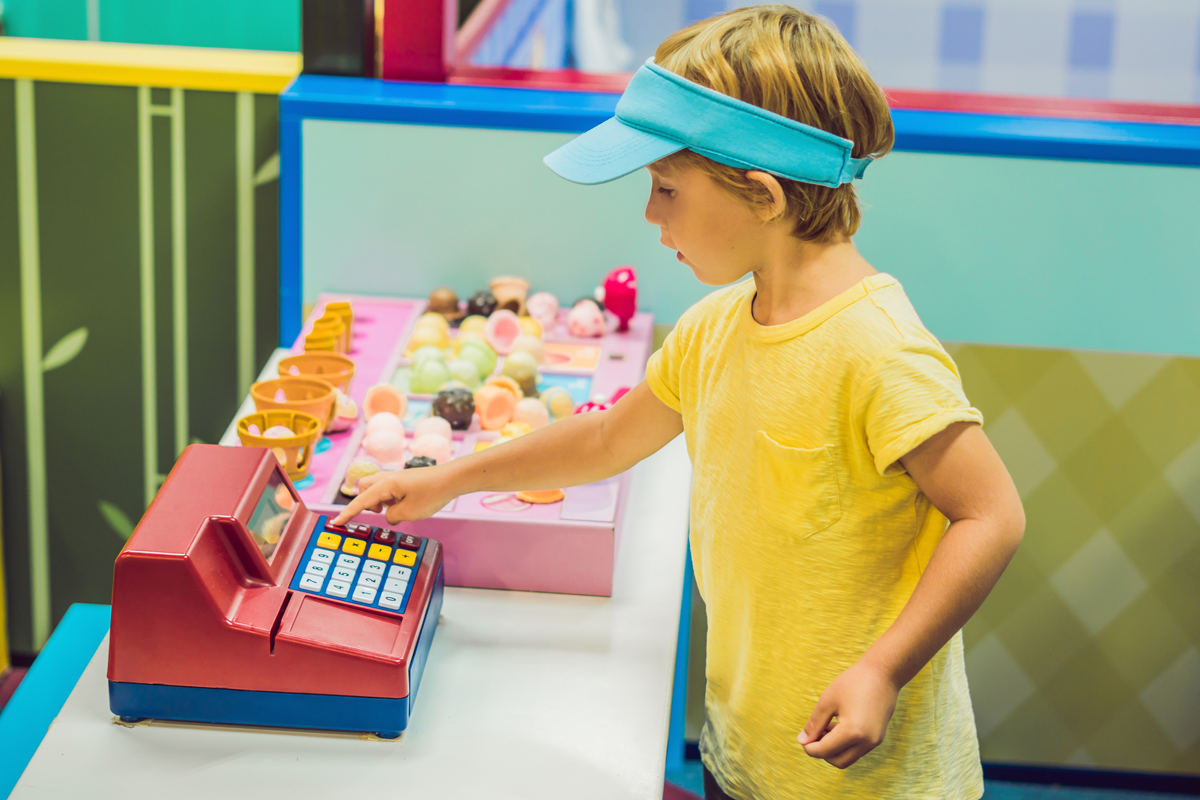 Child practicing math on toy cash register