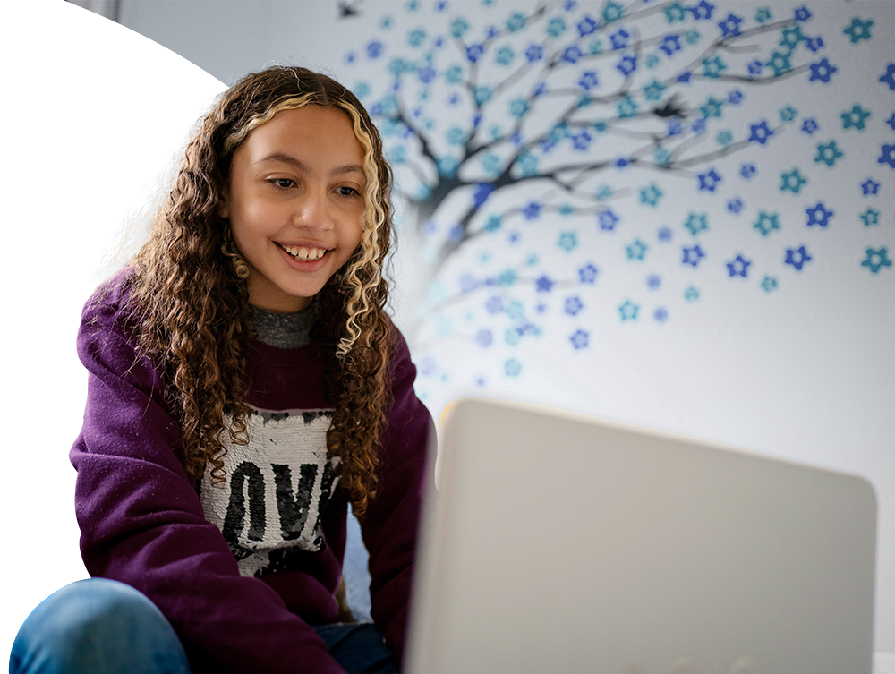 Middle school student sitting and typing on laptop