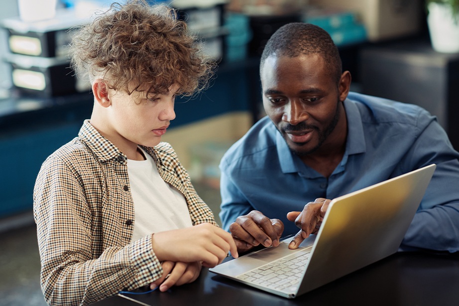 Student and teacher working together on a laptop