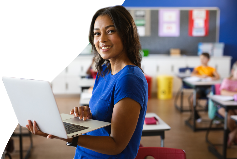 Teacher at the front of a classroom with a laptop