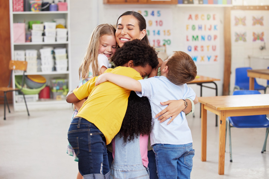 Students hugging teacher