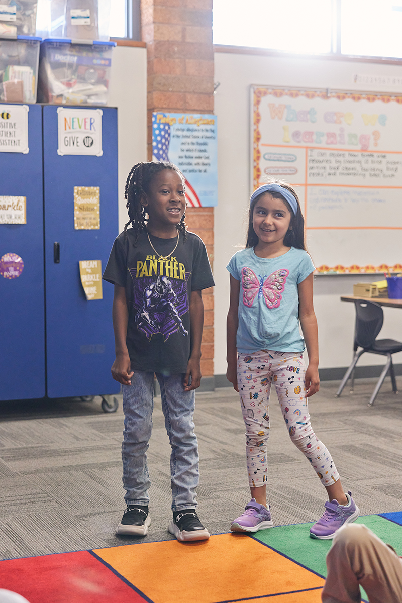 Two students stand and sing a song about birds.
