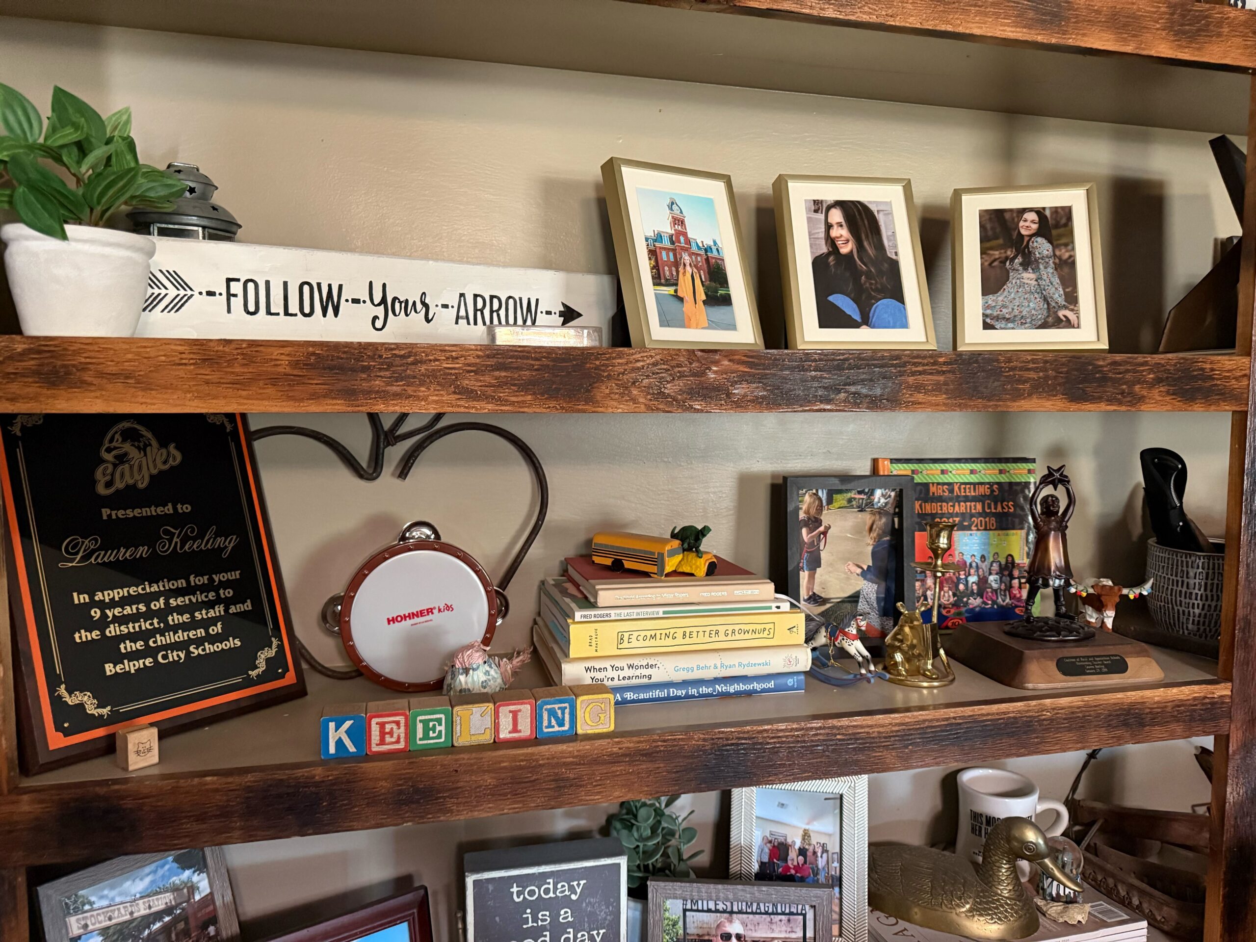 A shelf filled with photo frames, books and awards from Lauren Keeling's home.