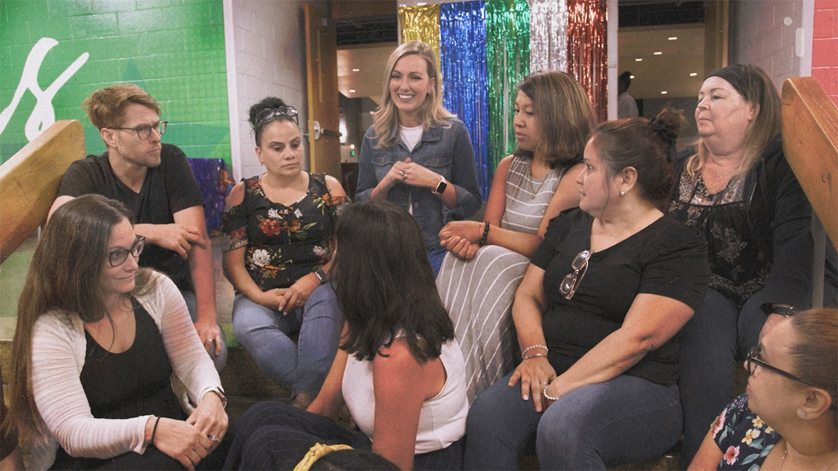 Lauren sits with a group of teachers discussing what they've learned during the training session. 