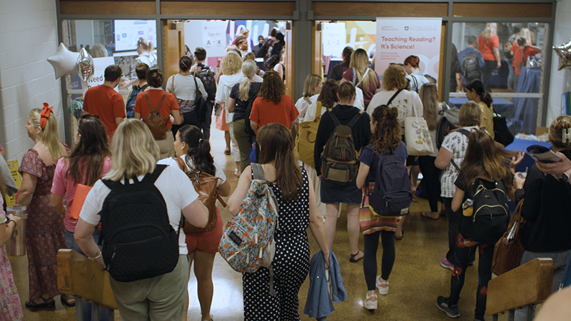 Educators and students walking in a hallway.