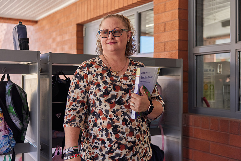 A group of educators pose for a photo in front of a backdrop.
