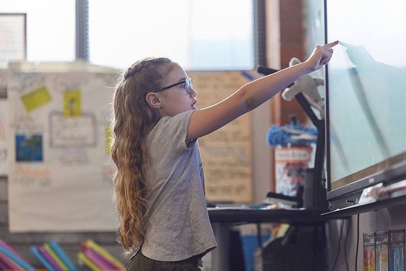 A group of educators pose for a photo in front of a backdrop.