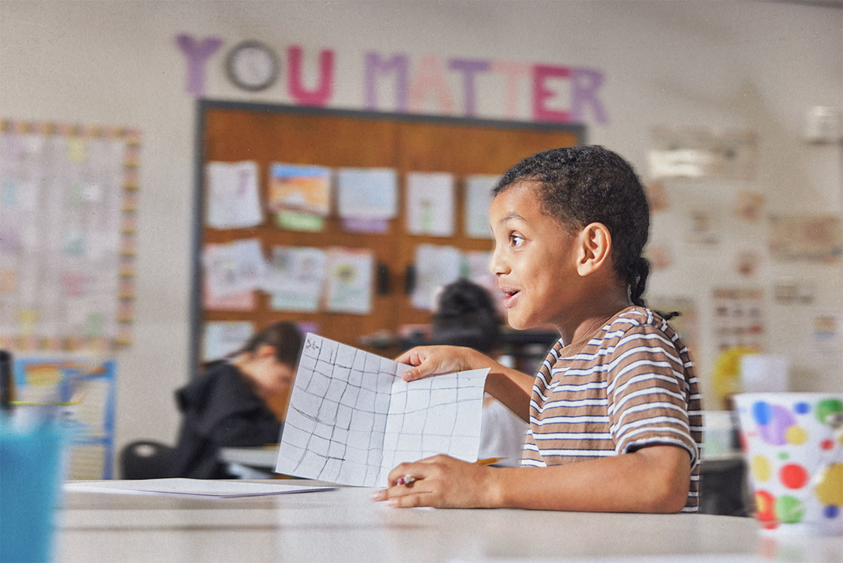 Student showing his work in a classroom.