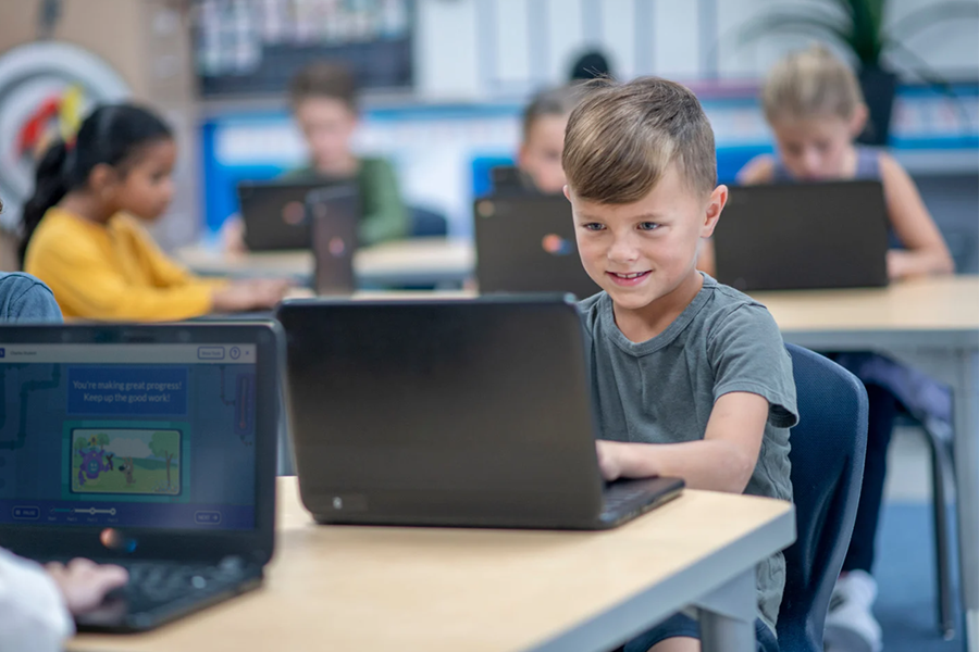 students on laptops taking benchmark assessments