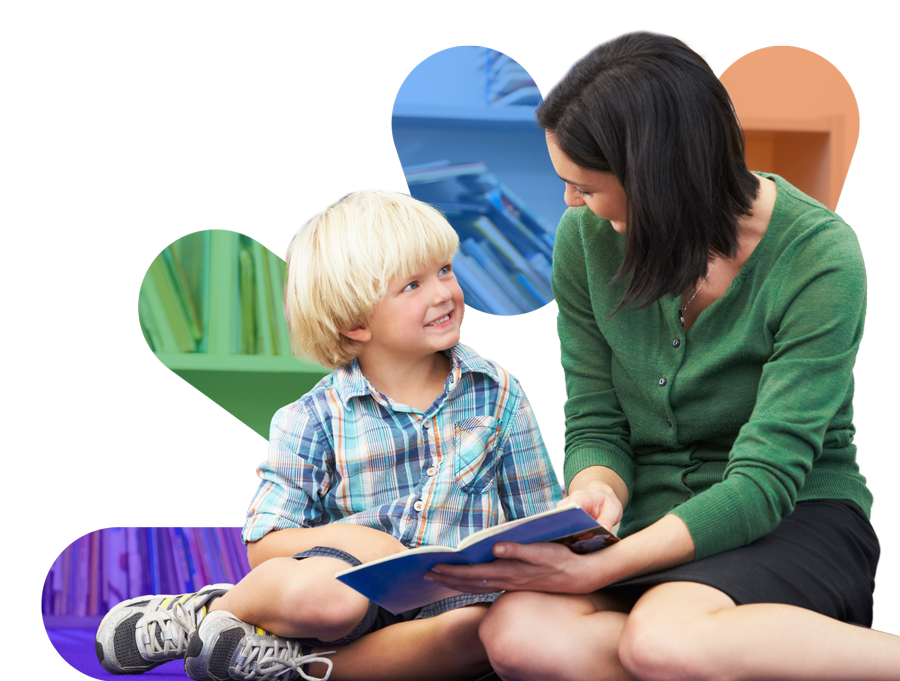 Teacher and young student reading book together