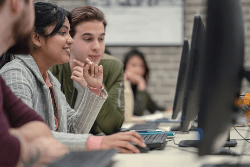 Teacher assisting high school student in class