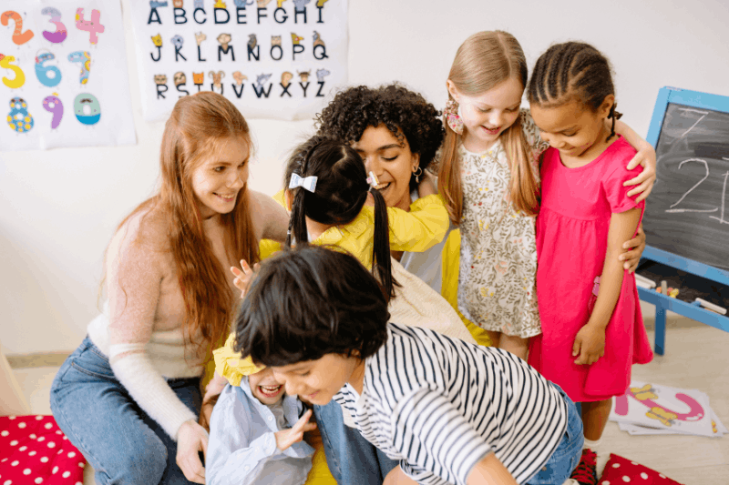 a group of adults and children interacting with each other in a Day Care setting