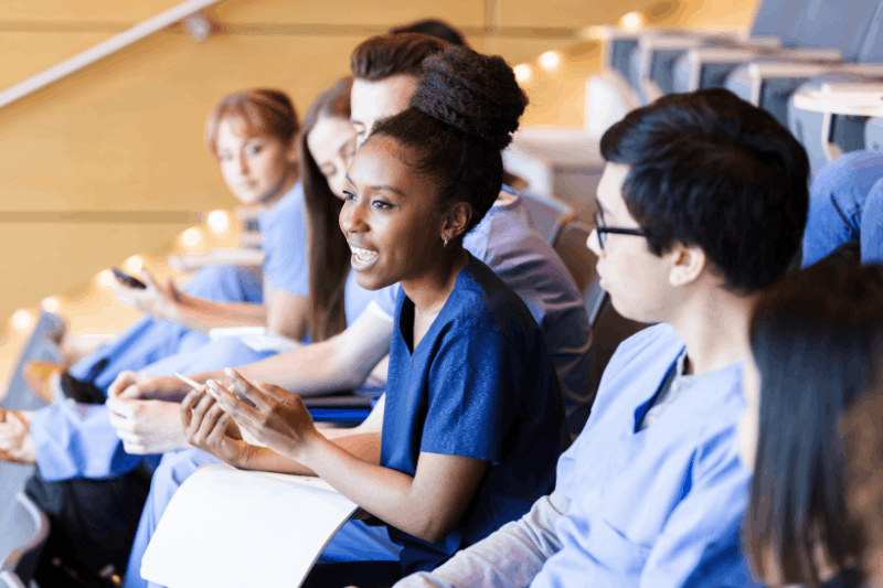 A group of nursing professionals sitting in a auditorium 