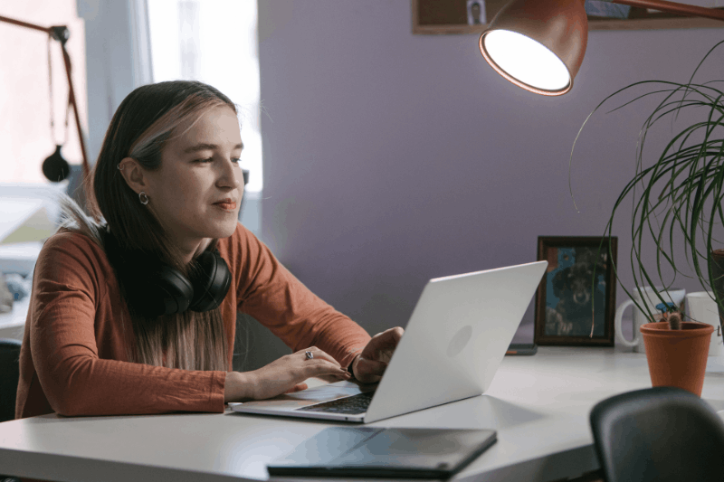 a young lady sitting in front of a laptop