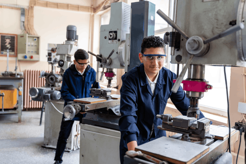two people both working on the manufacturing stations 