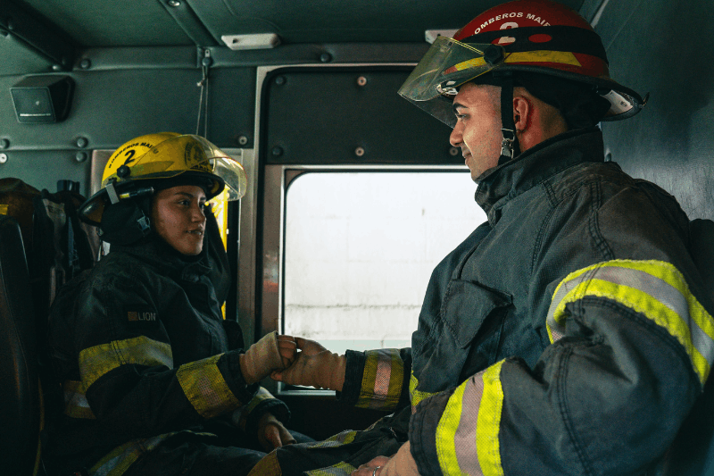 two firefighters sitting in a firetruck 