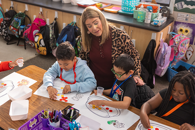 teacher with a small group of students working on a math assignment