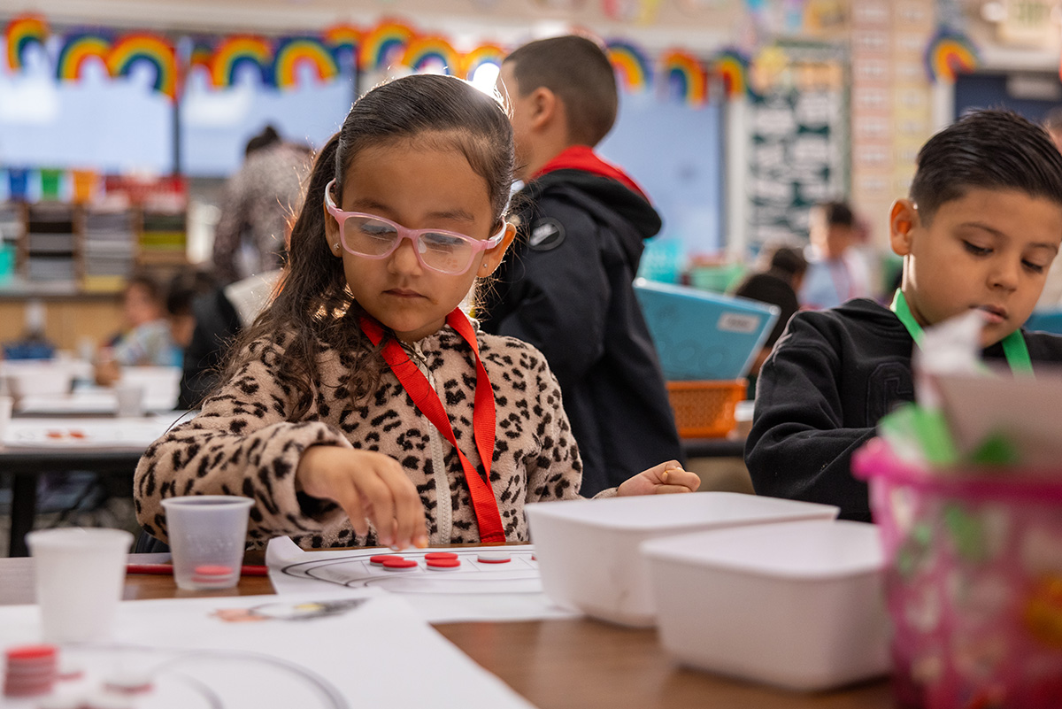 Image of student using manipulatives to solve a math puzzle.